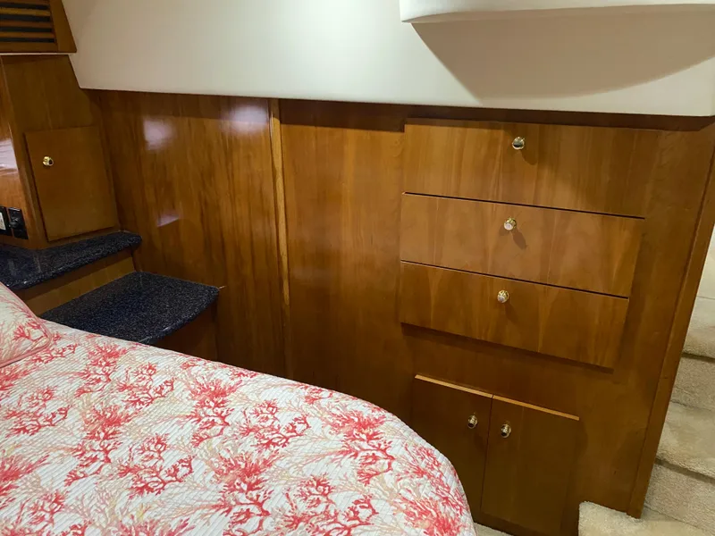 Slide: The Image of Interior of 2000 Carver 396 Motor Yacht with wooden cabinetry and floral bedspread. - 24
