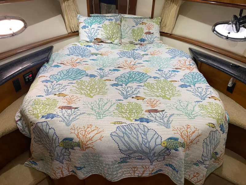 Slide: The Image of Carver 396 Motor Yacht 2000 bedroom with ocean-themed bedding. - 29