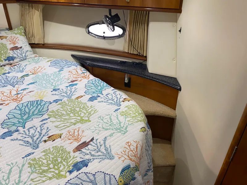 Slide: The Image of Interior cabin of a 2000 Carver 396 Motor Yacht with a colorful marine-themed bedspread. - 30