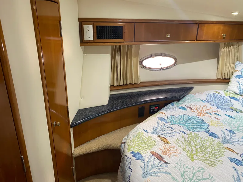 Slide: The Image of 2000 Carver 396 Motor Yacht bedroom with wood cabinetry and porthole window. - 31