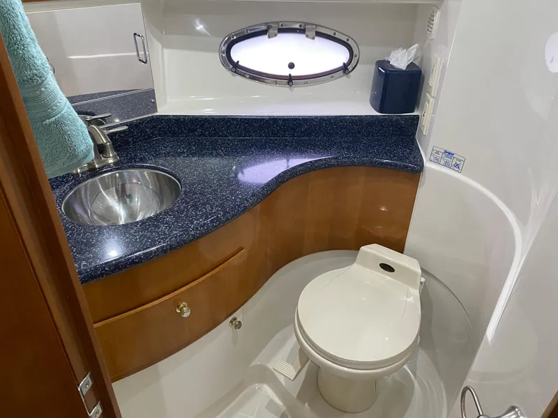 Slide: The Image of 2000 Carver 396 Motor Yacht bathroom with sink, toilet, and porthole window. - 32