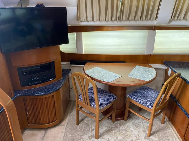 Slide: The Image of Interior of 2000 Carver 396 Motor Yacht with dining area and mounted TV. - 36