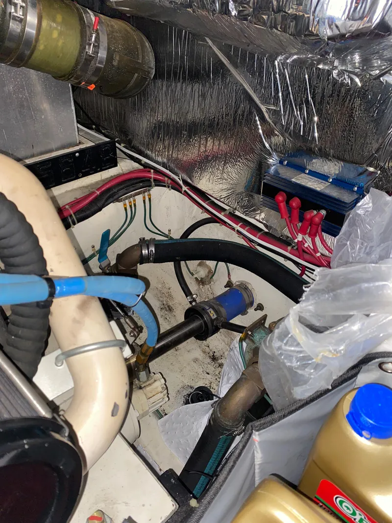 Slide: The Image of Engine compartment of a 2000 Carver 396 Motor Yacht with various hoses and components. - 42