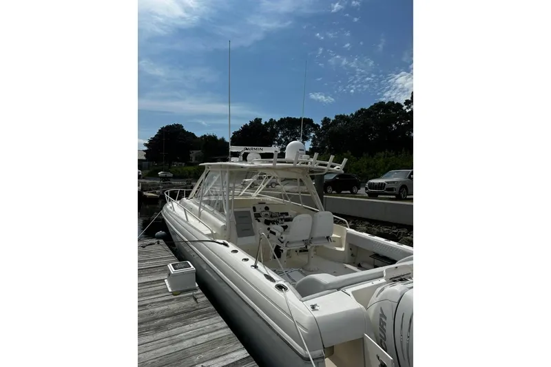 Slide: The Image of 2004 Intrepid 377 Walkaround boat docked under a clear blue sky. - 3