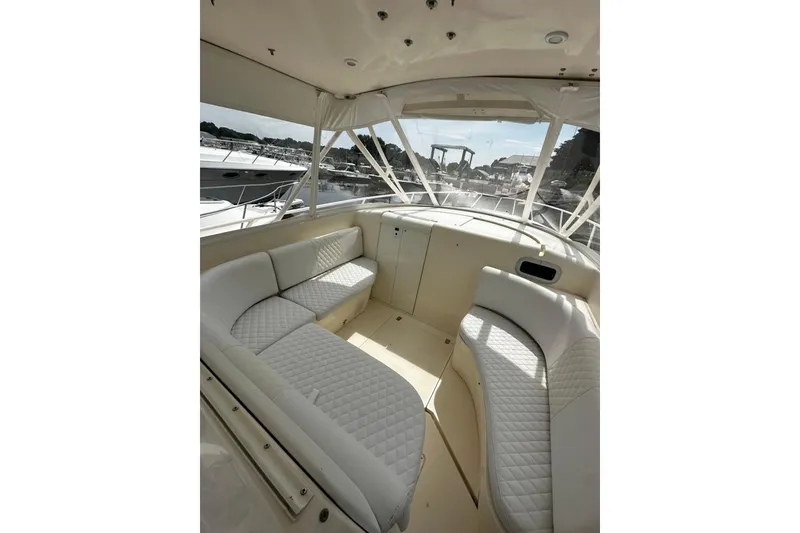 Slide: The Image of Interior of a 2004 Intrepid 377 Walkaround boat with white seating and panoramic windows. - 7