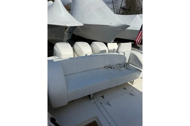 Slide: The Image of 2004 Intrepid 377 Walkaround boat with cushioned seating and multiple outboard engines. - 8