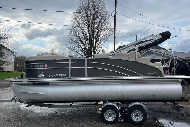 Slide: The Image of 2023 Harris Cruiser 190 pontoon boat on trailer, cloudy sky. - 5