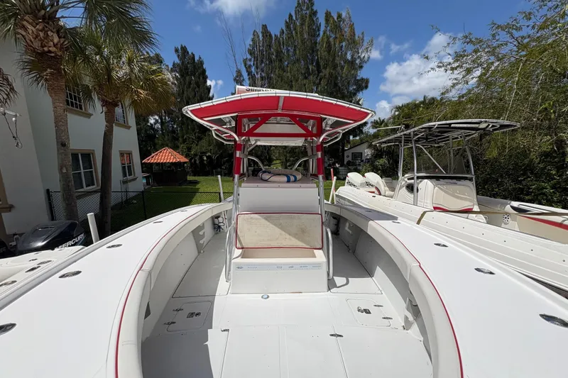 Slide: The Image of 2002 Ocean Runner 30 boat with red canopy, docked outdoors under blue sky. - 16