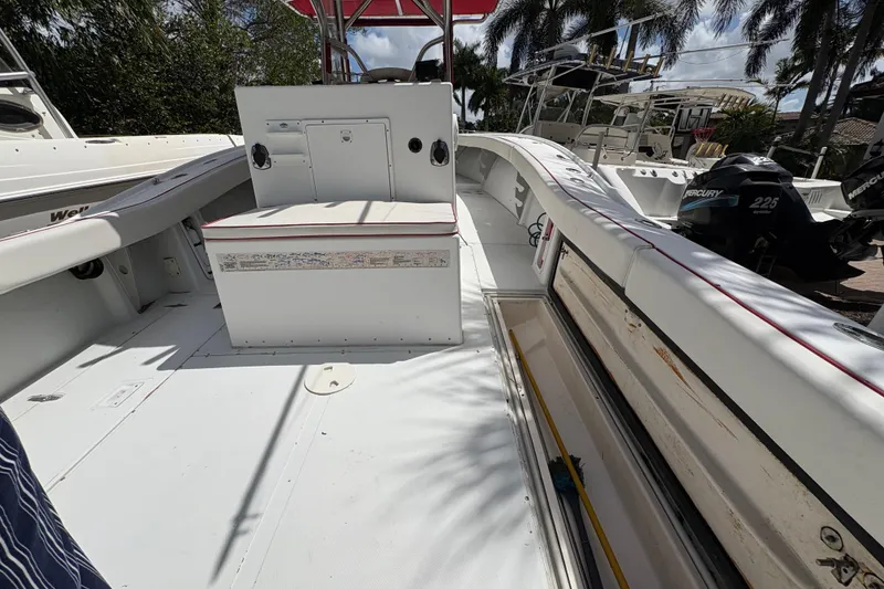 Slide: The Image of 2002 Ocean Runner 30 boat interior with seating and storage, featuring Mercury engines. - 21