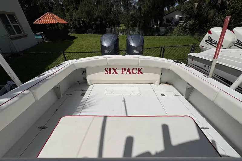 Slide: The Image of 2002 Ocean Runner 30 boat with "Six Pack" text, twin 300 engines, docked in a yard. - 5