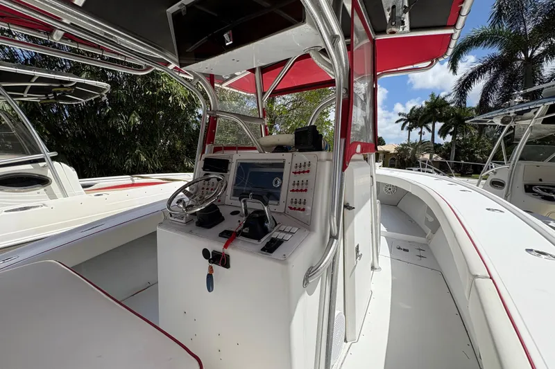 Slide: The Image of 2002 Ocean Runner 30 boat cockpit with steering wheel, control panel, and red canopy. - 7