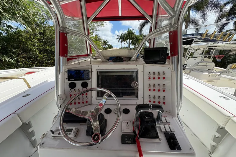 Slide: The Image of Control panel of a 2002 Ocean Runner 30 boat with steering wheel and navigation equipment. - 8