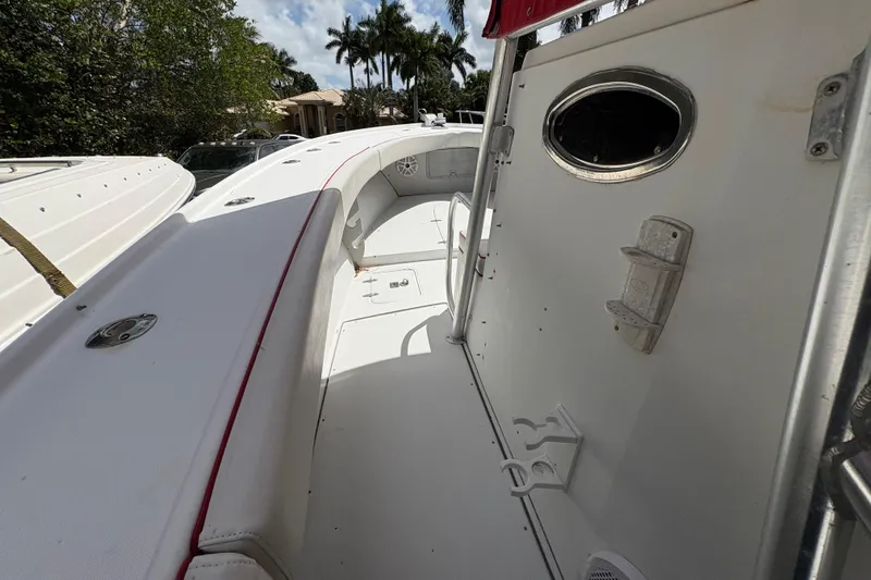 Slide: The Image of 2002 Ocean Runner 30 boat interior with white seating and red trim, surrounded by lush greenery. - 9