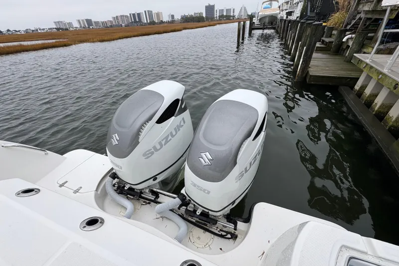 Slide: The Image of 2016 Boston Whaler 315 Conquest with twin Suzuki outboard engines docked by waterfront. - 12