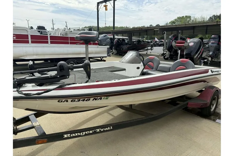 Slide: The Image of 2000 Ranger R81 boat on trailer, white with red accents, parked outdoors. - 11