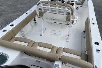 Slide: The Image of 2023 NauticStar 2302 Legacy boat interior with beige seating and white deck. - 6
