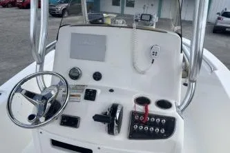 Slide: The Image of 2023 NauticStar 2302 Legacy boat dashboard with steering wheel and controls. - 8