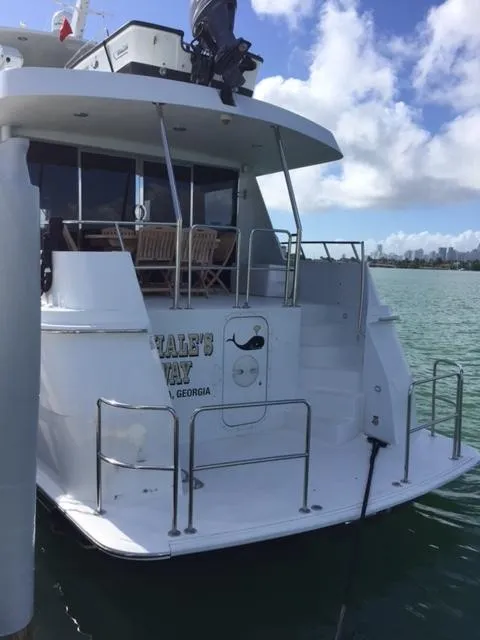 Slide: The Image of 1998 Hatteras 74 Sport Deck yacht docked with a view of the rear deck. - 24