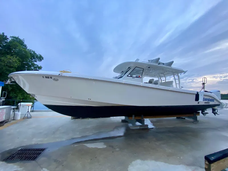 The Image of 2016 Everglades 435 Center Console boat on a dock, under a cloudy sky. - 0