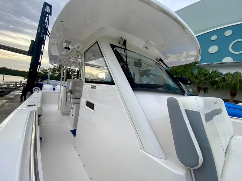 Slide: The Image of 2016 Everglades 435 Center Console boat, sleek design, docked outdoors. - 13