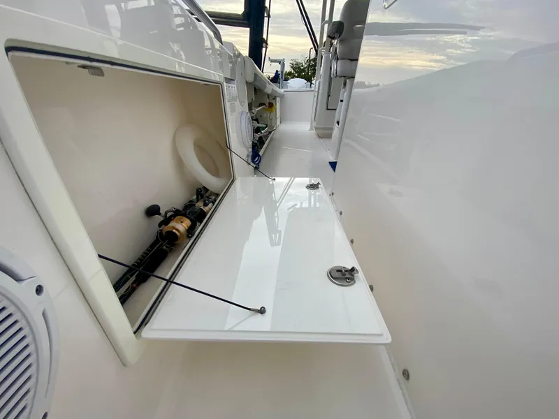 Slide: The Image of 2016 Everglades 435 Center Console storage compartment with open hatch, showcasing interior details. - 16