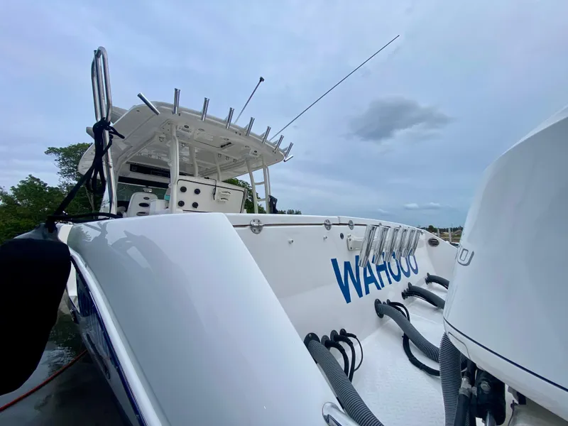 Slide: The Image of 2016 Everglades 435 Center Console boat with "Wahoo" lettering, docked under cloudy sky. - 2