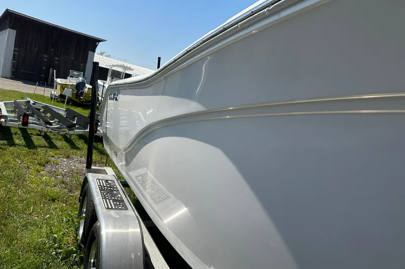 Slide: The Image of 2023 Sea Fox 228 Commander boat on trailer, side view in outdoor setting. - 4