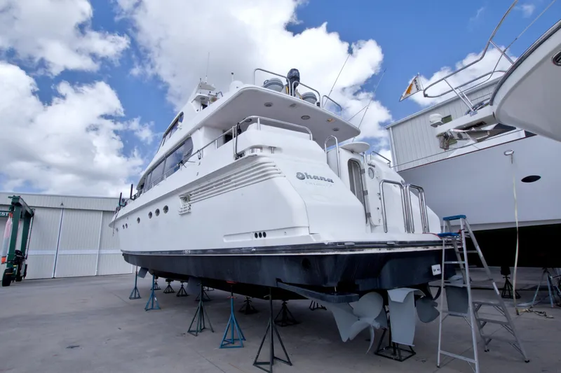 Slide: The Image of 1998 Lazzara 76 Skylounge Grand Salon yacht on dry dock under a blue sky. - 120