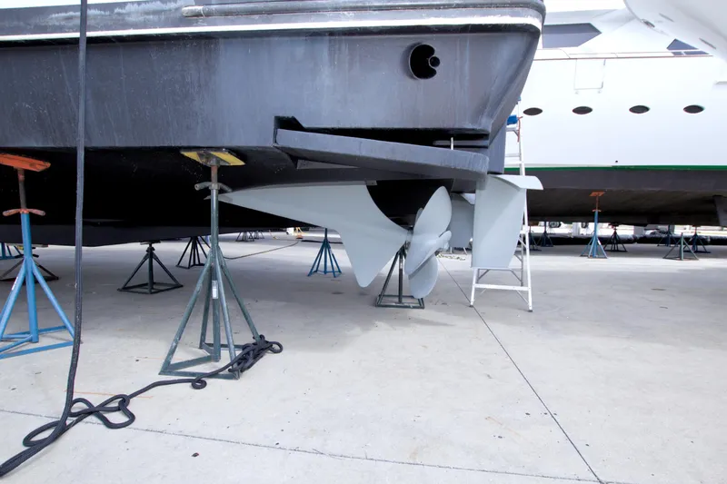 Slide: The Image of 1998 Lazzara 76 Skylounge Grand Salon yacht on stands, showcasing propeller and hull details. - 121