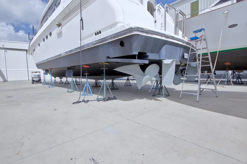 Slide: The Image of 1998 Lazzara 76 Skylounge Grand Salon yacht on stands, showcasing propellers and hull. - 122