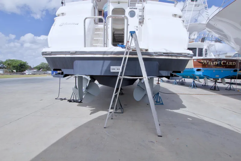 Slide: The Image of 1998 Lazzara 76 Skylounge Grand Salon yacht on dry dock with visible propellers. - 123