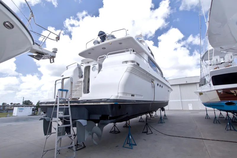 Slide: The Image of 1998 Lazzara 76 Skylounge Grand Salon yacht on dry dock under a bright blue sky. - 126