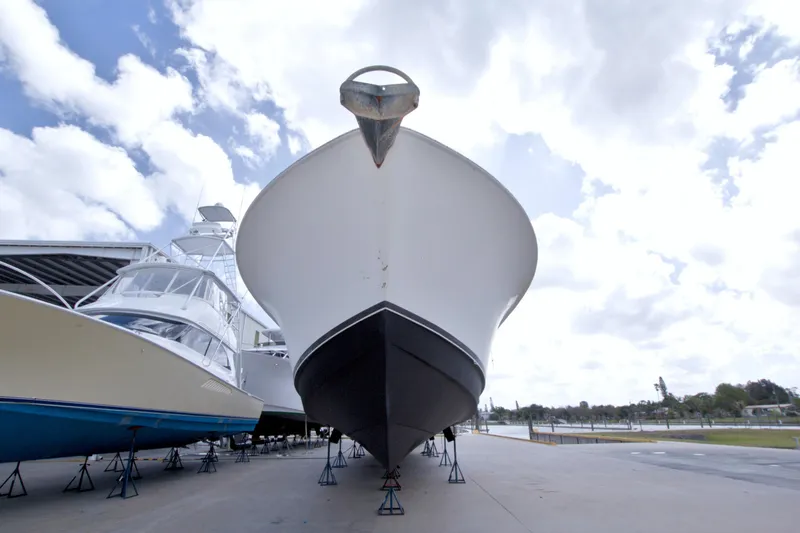 Slide: The Image of 1998 Lazzara 76 Skylounge Grand Salon yacht on dry dock under cloudy sky. - 130