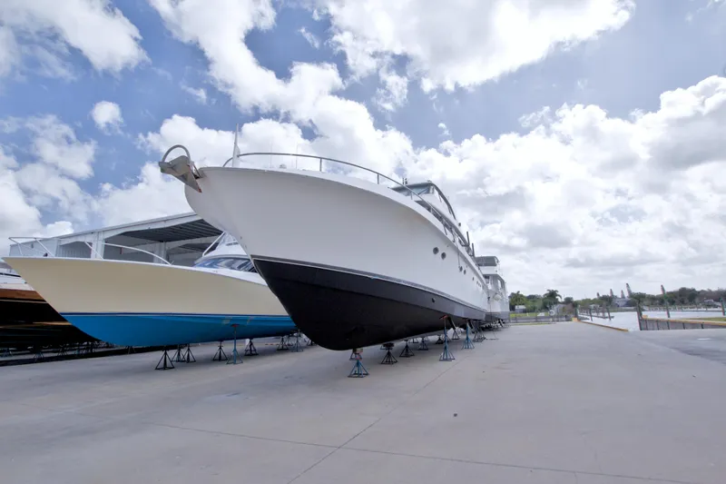 Slide: The Image of 1998 Lazzara 76 Skylounge Grand Salon yacht on dry dock under cloudy sky. - 131