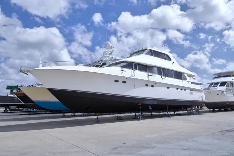 Slide: The Image of 1998 Lazzara 76 Skylounge Grand Salon yacht on dry dock under a cloudy sky. - 132