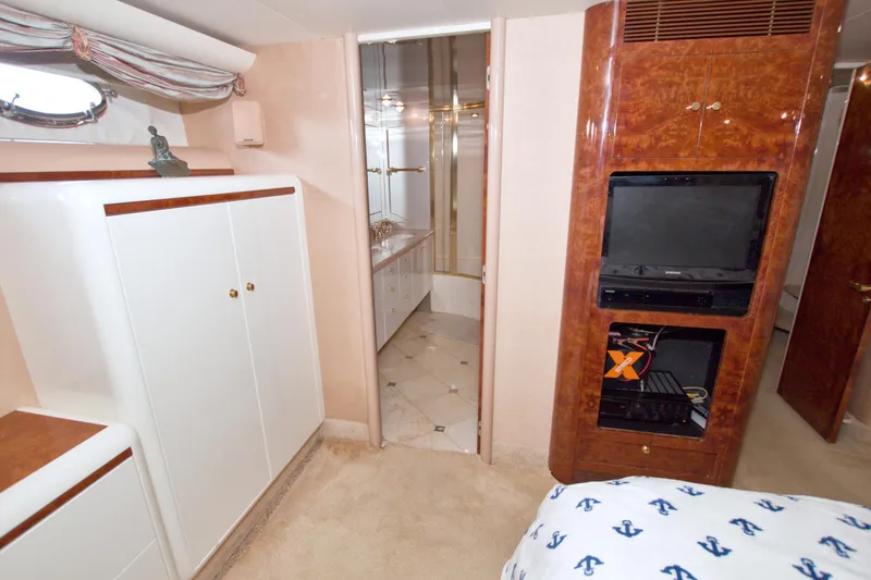 Slide: The Image of Interior of 1998 Lazzara 76 Skylounge Grand Salon yacht, featuring elegant cabinetry and entertainment system. - 21