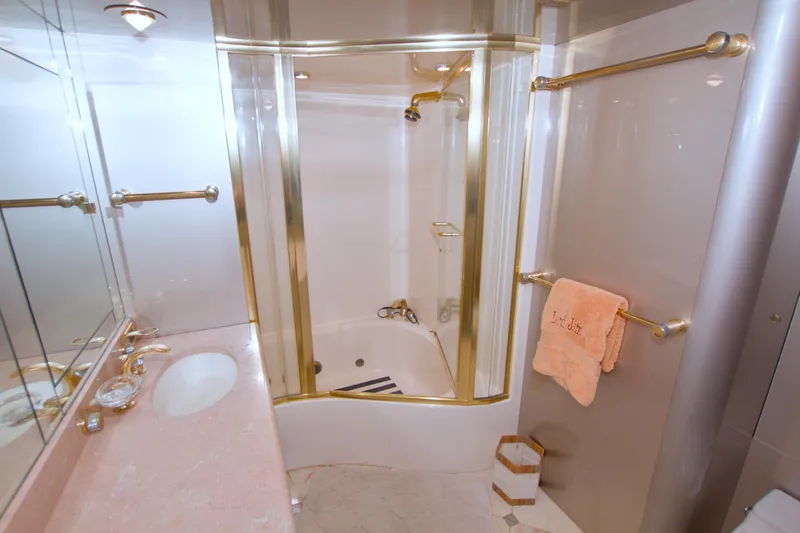 Slide: The Image of Luxurious bathroom in 1998 Lazzara 76 Skylounge Grand Salon yacht with gold accents and marble countertop. - 23