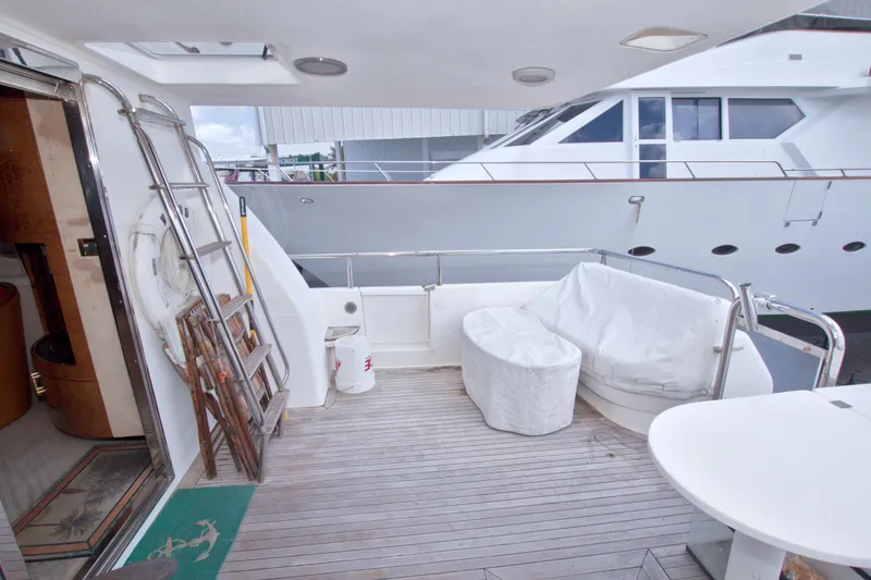 Slide: The Image of 1998 Lazzara 76 Skylounge Grand Salon yacht deck with seating and ladder. - 5