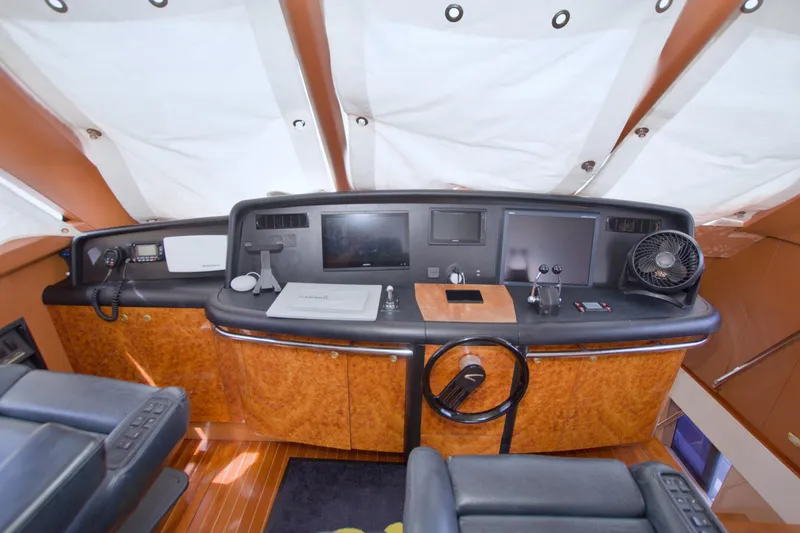 Slide: The Image of 1998 Lazzara 76 Skylounge Grand Salon helm with wood finish and modern navigation equipment. - 56