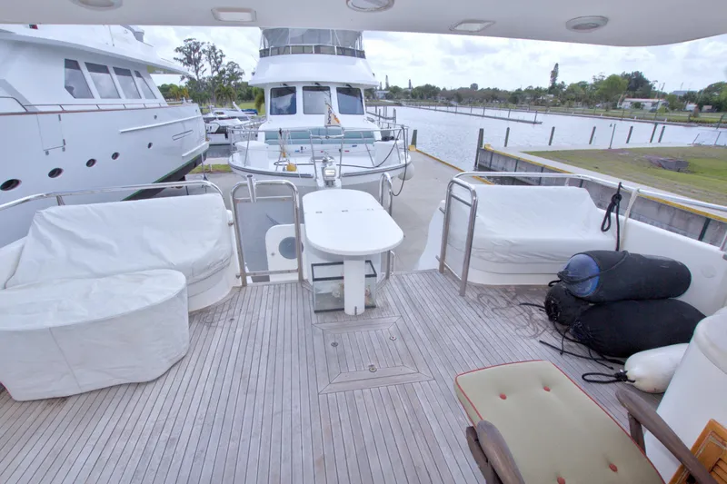 Slide: The Image of Spacious deck of 1998 Lazzara 76 Skylounge Grand Salon yacht, featuring seating and table. - 6