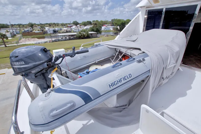 Slide: The Image of 1998 Lazzara 76 Skylounge Grand Salon yacht with covered Highfield tender and Yamaha outboard motor. - 64