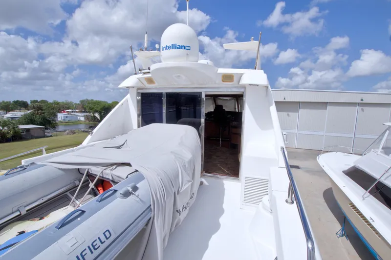 Slide: The Image of 1998 Lazzara 76 Skylounge Grand Salon yacht with covered deck and clear blue sky. - 65