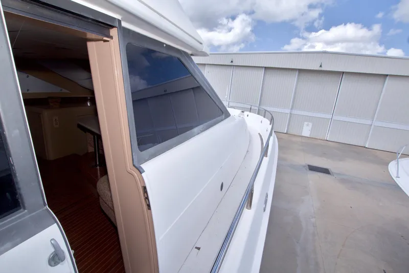 Slide: The Image of 1998 Lazzara 76 Skylounge Grand Salon yacht exterior with open door and dock view. - 71