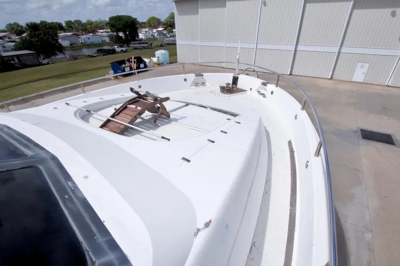 Slide: The Image of 1998 Lazzara 76 Skylounge Grand Salon yacht deck, docked near a storage facility. - 72