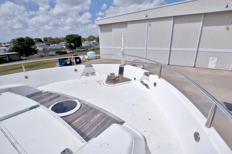 Slide: The Image of Deck view of 1998 Lazzara 76 Skylounge Grand Salon yacht near a storage facility. - 73
