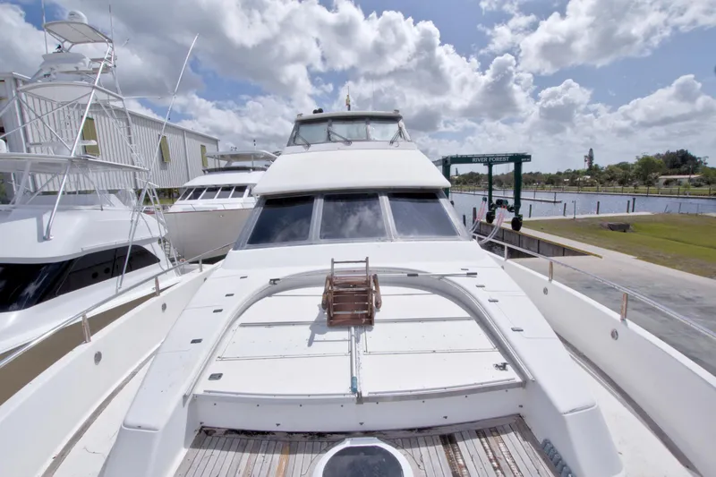Slide: The Image of 1998 Lazzara 76 Skylounge Grand Salon yacht docked under cloudy skies. - 76