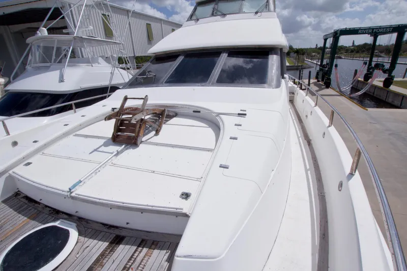 Slide: The Image of 1998 Lazzara 76 Skylounge Grand Salon yacht docked, showcasing sleek design and spacious deck. - 77