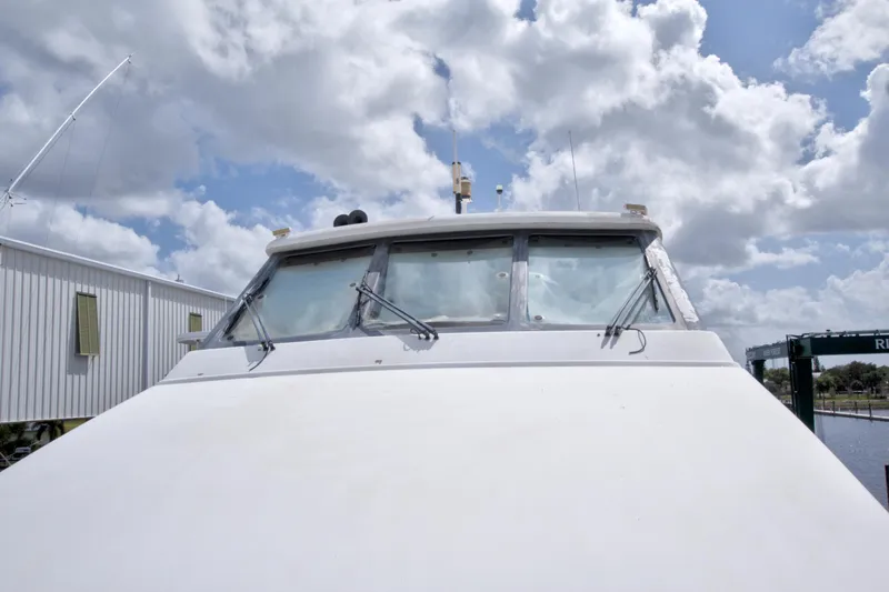 Slide: The Image of Front view of 1998 Lazzara 76 Skylounge Grand Salon yacht under cloudy sky. - 78