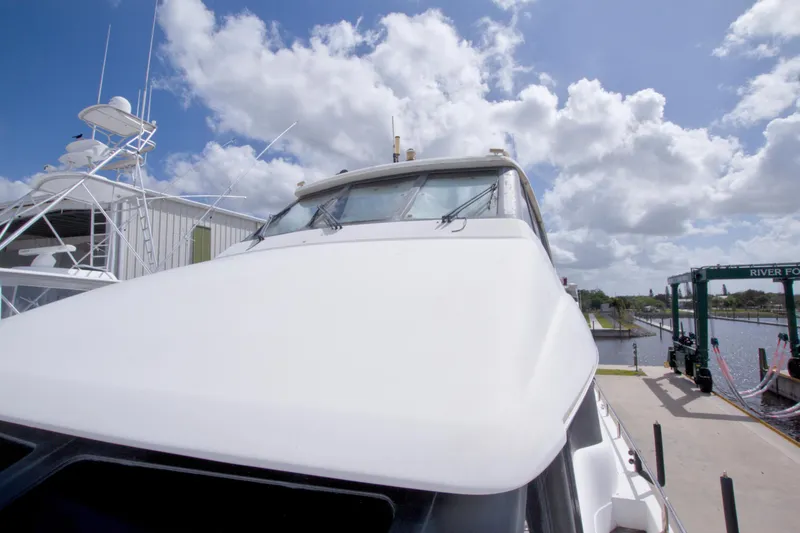 Slide: The Image of 1998 Lazzara 76 Skylounge Grand Salon yacht docked under a bright blue sky. - 79