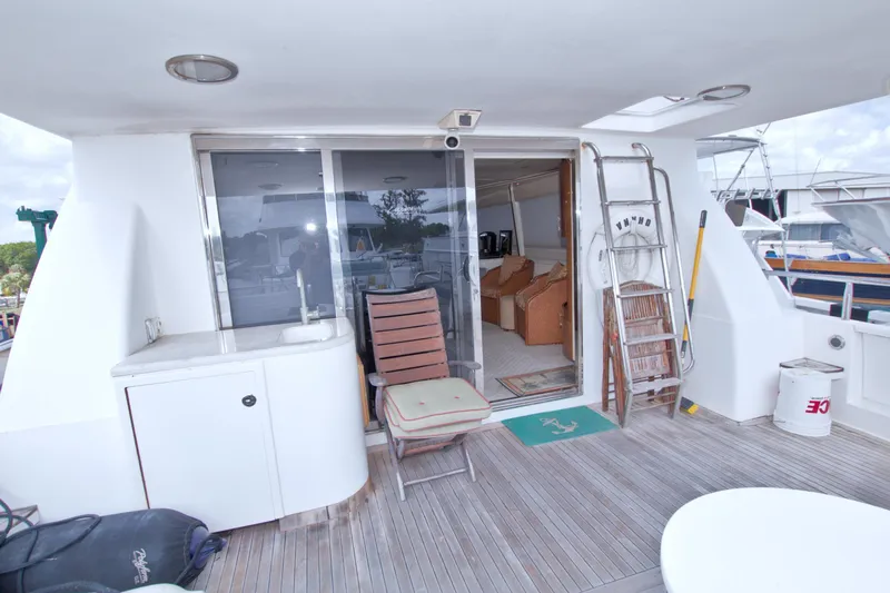 Slide: The Image of Outdoor deck of 1998 Lazzara 76 Skylounge Grand Salon yacht with seating and ladder. - 8